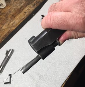 Place the take down tool into the hole in the guide rod
