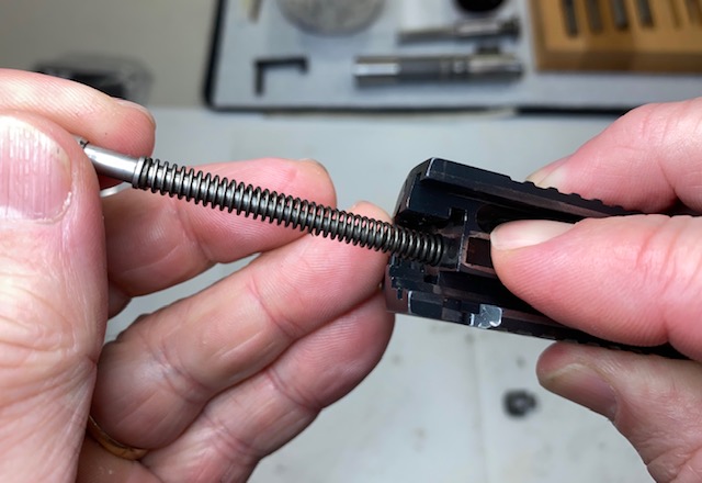 While pressing on the firing pin block, pull the firing pin and spring out of the slide
