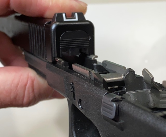 How to Field Strip & Clean a Glock 17 9mm or Glock 19 9mm Pistol: Flip the slide over and line it up with the rails on the frame as shown