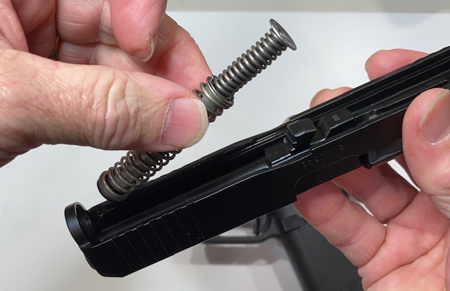 Lift and remove the recoil spring assembly