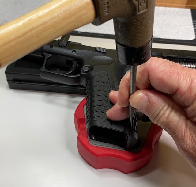 Using the punch and hammer, tap out the roll pin