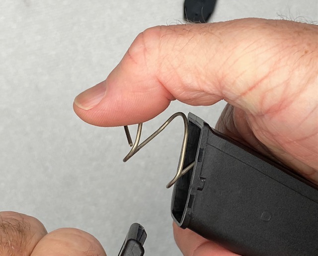 How To Remove a Glock Magazine Base Plate: Slowly move your thumb to allow the spring tension to be released