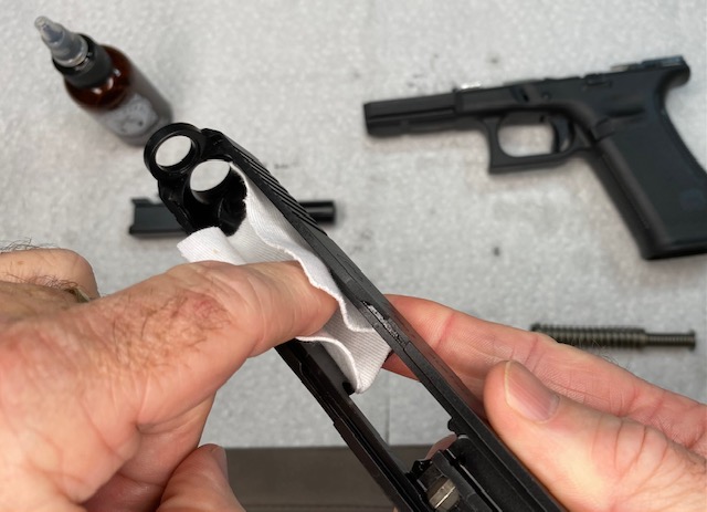 Glock Lubrication Guide: Wipe the Glock Slide in front of the ejection port with oil-dampened cloth