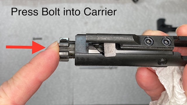 How to Disassemble & Clean An AR-15 Rifle: Press the bolt as far as it will go into the Carrier