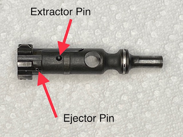 Locate the Ejector Pin on the side of the Bolt