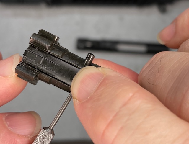 How to Disassemble an AR-15 BCG: While squeezing the extractor, push the Extractor Pin all the way out