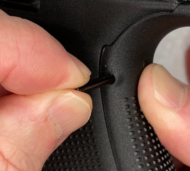 While squeezing the Backstrap to the grip, insert the longer Trigger housing Pin into the hole.