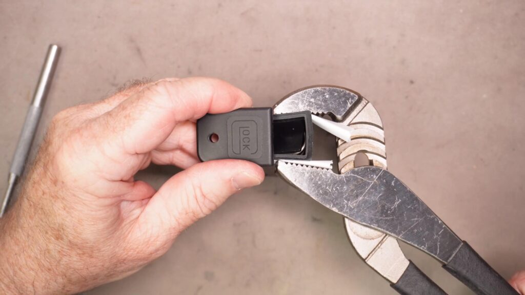 Using channel lock pliers to remove the Glock Magazine baseplate
