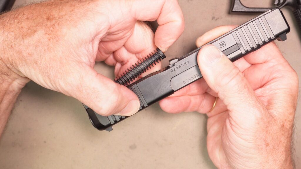 Compress and lift out the recoil spring assembly and the barrel
