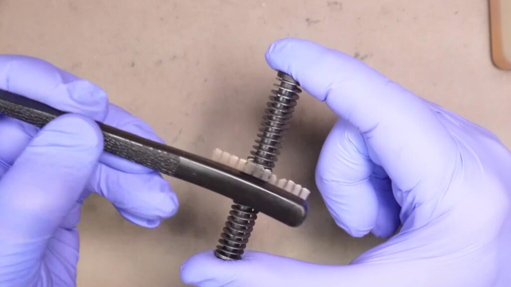 Clean the recoil spring assembly with a dry brush